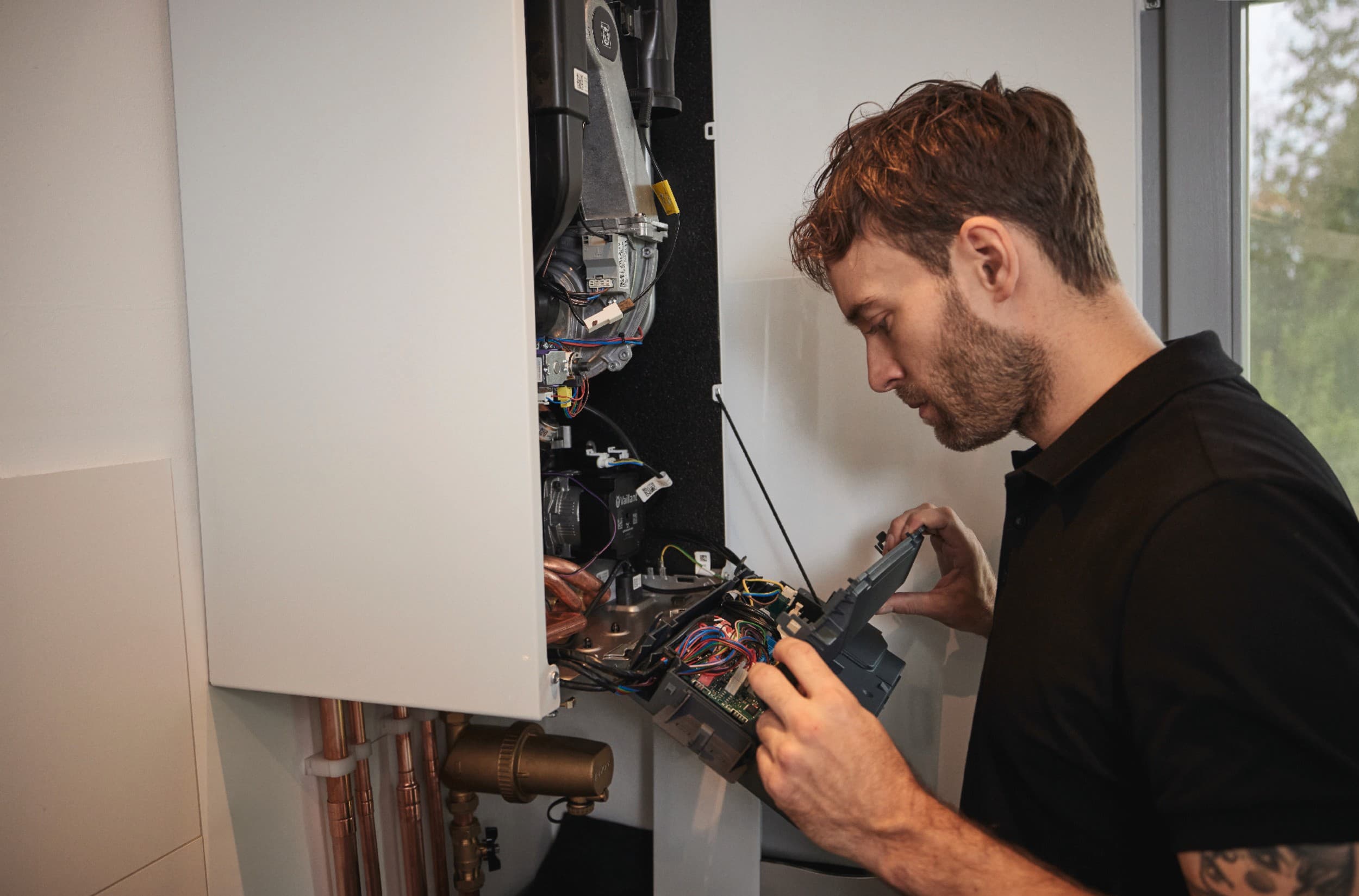 Tecnico ufficiale Vaillant che controlla il funzionamento di una caldaia a condensazione